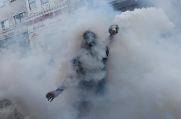 A demonstrator throws back a tear gas canister to riot police during an anti-government protest in central Istanbul