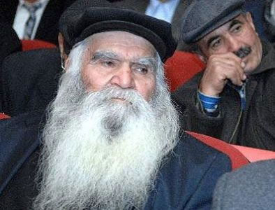 Aλεβίτης γέροντας-σοφός, που απολαμβάνει του σεβασμού της κοινωνίας των Αλεβιτών. Στο πρόσωπό του μπορεί να διακρίνει κανείς την ηρεμία και την πραότητα, χαρακτηριστικά των Αλεβιτών, σε αντιπαραβολή με το σκληρό βλέμμα των ιερωμένων Σουνιτών, στο οποίο επίσης αντικατοπτρίζεται η θρησκευτική οργή που υπάρχει στην σουνιτική κοινωνία, που εκφράζεται πολλές φορές με πράξεις ανείπωτης βίας.