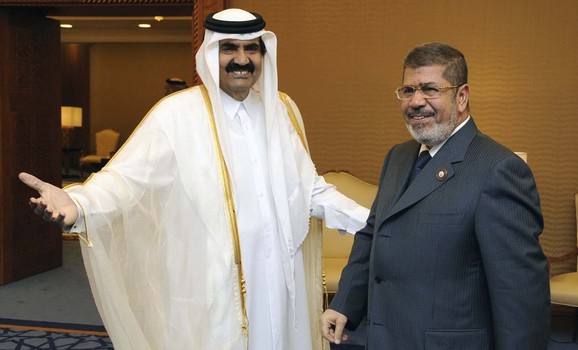 Qatar's Emir Sheikh Hamad bin Khalifa al-Thani greets Egypt's President Mohamed Mursi during the Arab League summit in Doha