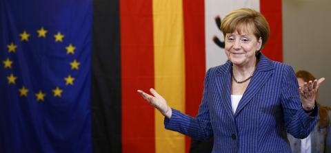 German Chancellor Merkel gestures after voting in the European Parliament election at a polling station in Berlin