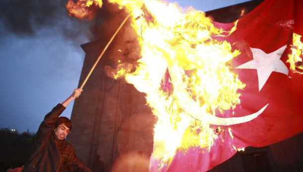 A demonstrator sets fire to a Turkish flag as he attends a torch-bearing march marking the anniversary of the 1915 mass killings of Armenians in Ottoman Empire, in Yerevan April 23, 2010.  REUTERS/Vahan Stepanyan/PanARMENIAN Photo/Handout (ARMENIA - Tags: POLITICS CIVIL UNREST ANNIVERSARY IMAGES OF THE DAY) FOR EDITORIAL USE ONLY. NOT FOR SALE FOR MARKETING OR ADVERTISING CAMPAIGNS