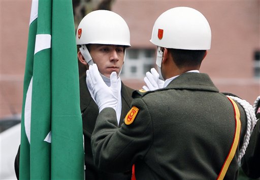 A Turkish army officer adjusts the helmet of one of his soldiers, member of the Presidential guard of honour who is holding a Pakistan flag before a welcome ceremony for Pakistani Prime Minister Yousuf Reza Gilani in Ankara, Turkey, Tuesday, Oct. 28, 2008. Gilani is in Turkey for a four-day visit and he will also attend the World Economic Forum in Istanbul on Thursday.(AP Photo/Burhan Ozbilici)